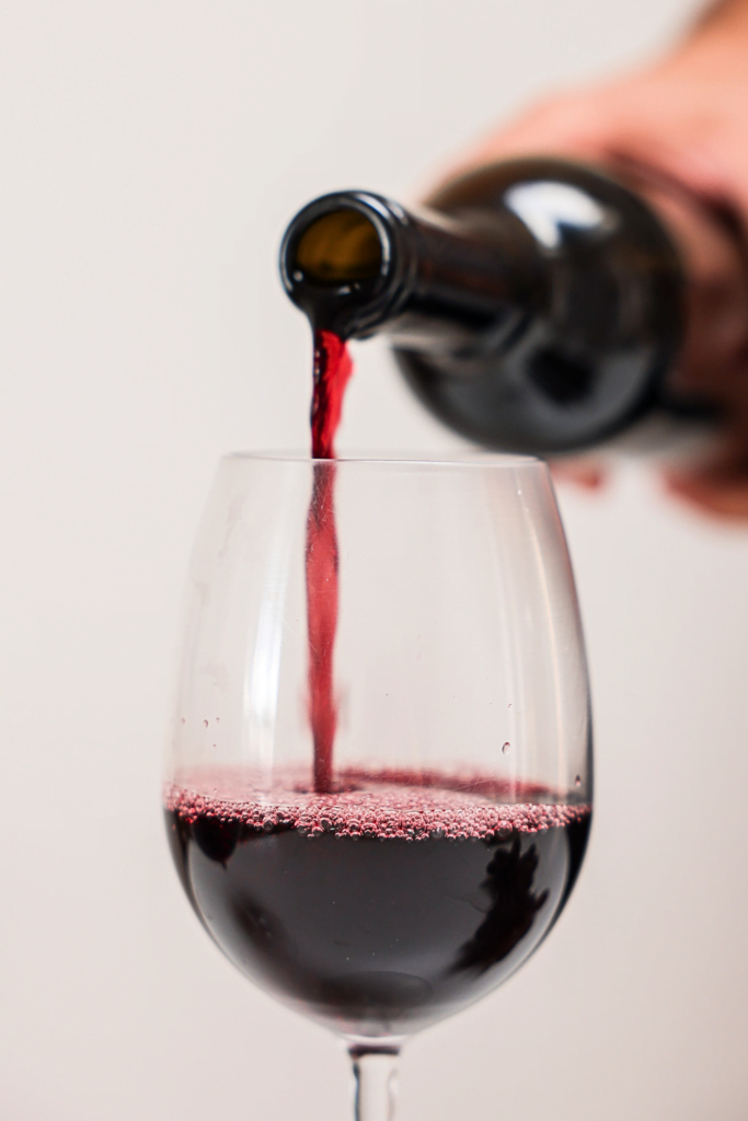 sirviendo una copa de vino tinto