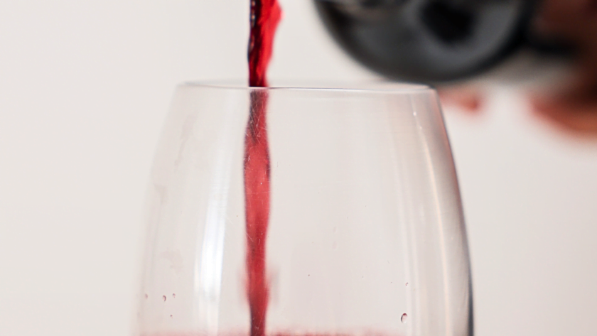 sirviendo una copa de vino tinto