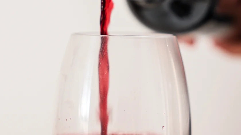 sirviendo una copa de vino tinto