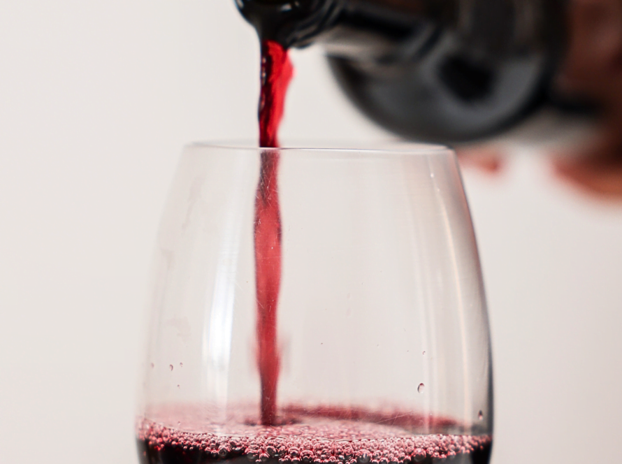 sirviendo una copa de vino tinto